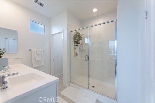 walk in shower with white subway tiles,  toilet future in room to the left in photo