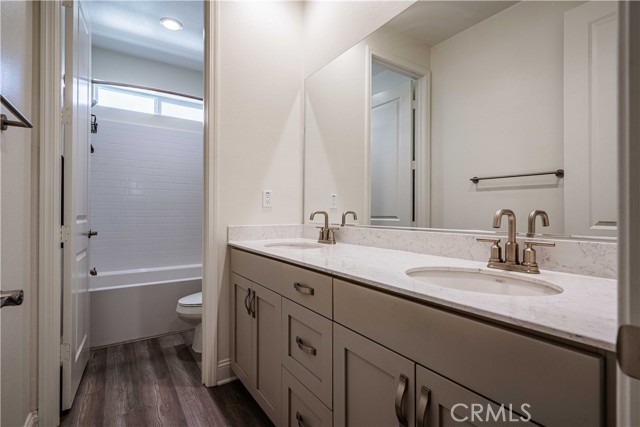 The last full bathroom down the hall is inbetween bedrooms 3 and 4 upstairs. A nice shareable space with dual sinks, dolphin grey cupboards wirh stainless steel hardware. A clever design allows you to close the door to use the water closet/tub/shower combo while someone could be using the sinks in the front half. Wood laminate flooring and recessed lighting above.