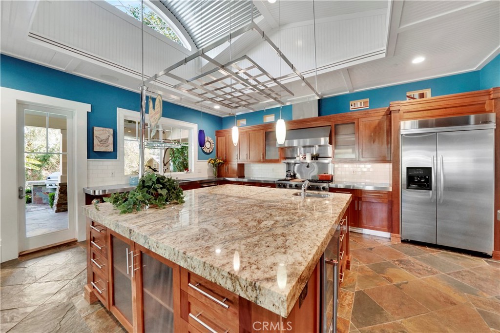 huge center island has granite top and stainless steel access strips