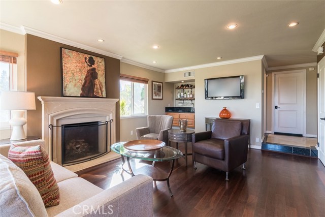 Family room with it's stone fireplace for those chilly nights  and wet bar for more entertaining. The door connects to the Garage for easy convenient access to cars and storage