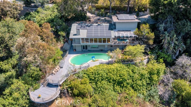 Great opportunity for those seeking to renovate or develop their dream home in the prestigious 90210 neighborhood. This exquisite mid-century modern estate is nestled among lush hills in upper Benedict Canyon, occupying 1.5-acre grounds that provide a serene and private oasis, offering sweeping canyon views from nearly every room. With its timeless design and being conveniently close to Beverly Hills' finest restaurants, Rodeo Drive, and the renowned Beverly Hills Hotel, this property offers an idyllic retreat, combining tranquility with unmatched convenience.