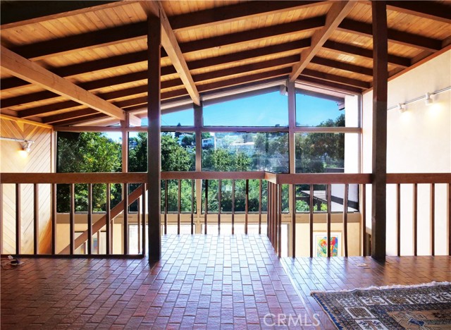 Dramatic high beam ceilings with stairway leading to Family Room with fireplace, wet bar and guest quarters including bath with attached sauna