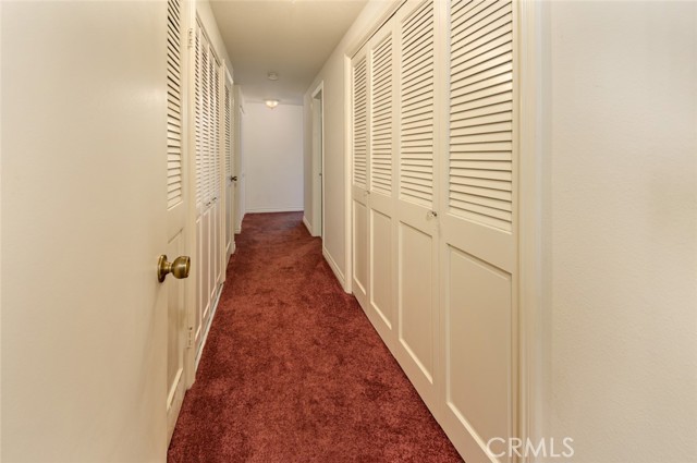 Long hallway with alot of closet space including individual closet with washer & dryer.