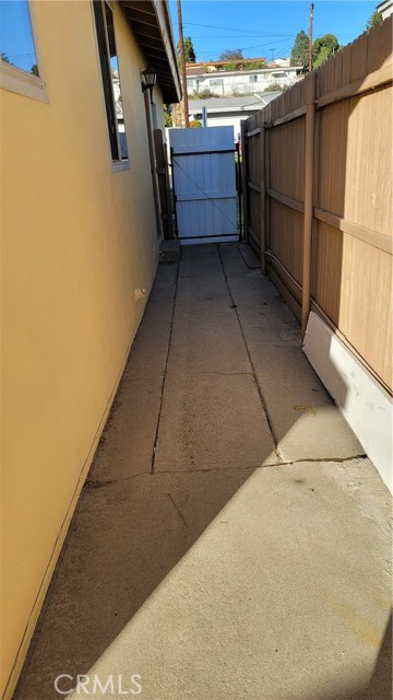 East side of house, facing towards gate leading to front of house.