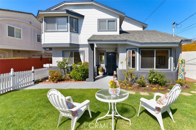 The front of the home with newly painted trim, exterior, and front door as well as new landscaping,