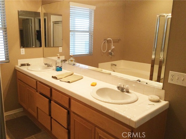 Master bathroom, dual sinks, separate tub and shower in back ground.