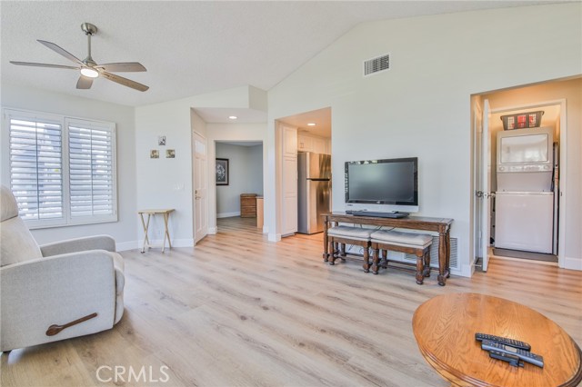 Main living room and dining area with LVP floors, vaulted ceilings, clerestory windows, lots of light