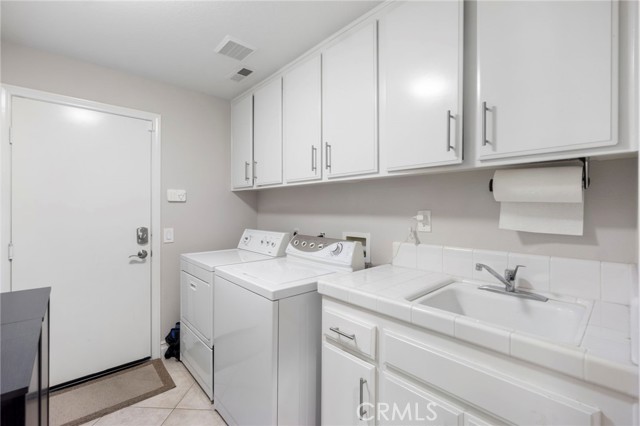 Downstairs Laundry Room with sink and storage