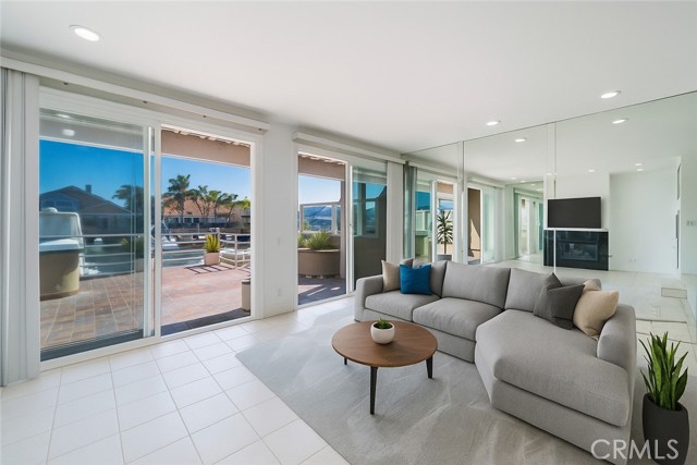 Virtually Staged- Open living space with fireplace, open to dining room and kitchen.  Built in wet bar.  With two sliders opening to patio with waterfront view.