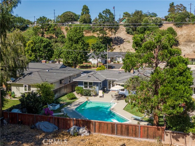 Aerial view of backyard and the back of the home. Lots of trees in the area