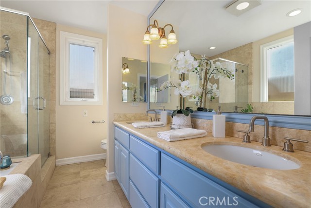 Primary Suite bathroom with double sink, soaking tub and glass enclosed step in shower.