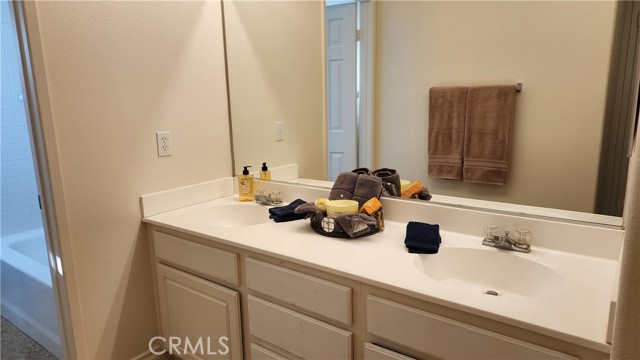 Secondary Upstairs Bathroom with dual sink and separate bath/shower and toilet area
