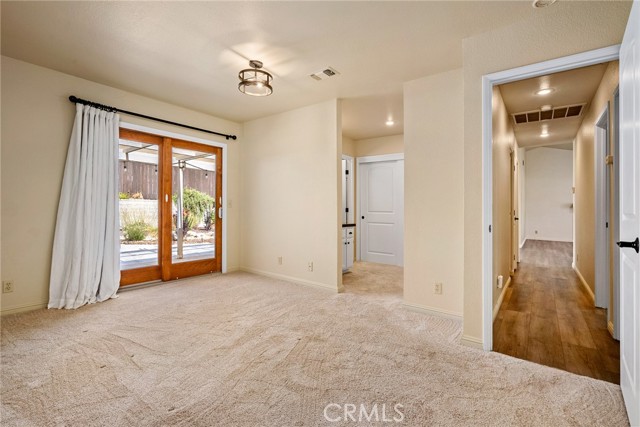 At the end of the hallway is the primary suite with a large sliding glass door which leads to the backyard.