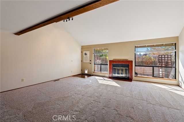 Anchored in the middle of two tall windows is a tile-surround fireplace.