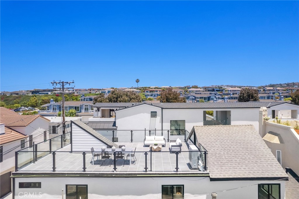 Enjoy the Corona Del Mar lifestyle in this recently renovated, detached, four-bedroom townhome-style rear unit. Offering privacy, coveted city and ocean views from its expansive rooftop, and designer elements throughout, it offers the best of Village living. The main level of this extensively upgraded home with an extra-high vaulted ceiling is located on the second floor and features an open entertaining area composed of a living room and a kitchen. Bright and airy, this space is as charming as it is functional - kitchen highlights include a Quartz waterfall peninsula with seating, a suite of Bertazzoni appliances, and ample custom cabinet storage. Three bedrooms on this level include the primary suite and its adjacent bathroom with a double vanity and a walk-in shower with Bedrosians tile. The ample size of the home’s rooftop deck allows for several sitting areas and enjoyment of views of the ocean, city lights, and the mountains beyond. The fourth ensuite bedroom is located on the ground level and could serve as a perfect home office or private guest quarters. Additional property features include wall air conditioning units, wide-plank wood flooring throughout, recessed lighting, and updated piping. Desirable location in the quiet portion of the Village, just minutes away from shopping, dining, and the area’s picturesque beaches.