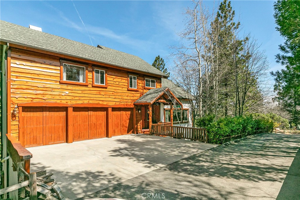 An Extraordinary Opportunity Awaits In One Of Lake Arrowhead's Most Sought After Summit Locations Adjacent to the National Forest! This custom lodge estate is situated on half an acre custom built by one of Lake Arrowhead's most esteemed lodge home builders, John Bueller. A five star retreat providing authentic mountain ambiance coupled with modern luxury and smart home functionality at your finger tips.  The hand hewn timbers and custom features are reminiscent to one would expect only attainable in an Aspen or Montana life style setting.  Majestically positioned on a landscaped knoll you are greeted by picturesque tree and skyline views upon entry.  The interior of home offers an open concept floor plan with a two story great room open to dining and kitchen- Accented with beamed ceilings, floor to ceiling windows, a masonry stone fireplace, and wood plank flooring.  The kitchen features a large center island, Viking appliances, and is conveniently accessible to a beautiful expansive redwood deck accommodating alfresco living for indoor-outdoor entertaining. The large primary suite has it's own upper level complete with private sitting area, spa inspired bath, fireplace, walk in closet, study, and outdoor decking. The lower level includes three well appointed guest rooms, a Zen like den, and a discreet ventilated cigar and wine room with an intimate media area fully self contained with wet bar, Sub Zero refrigeration and wood burning stove.  Turnkey furnishings and custom decor accents by celebrity interior designer Amber Lewis add a hip and happening vibe are available and negotiable in sale. The grounds offer a private resort like playground. After a day at the lake, float in the salt water pool, enjoy the sunken spa tub, the stone fire pit, all enhanced by a recirculating waterfall & pond with custom night lighting. There is even a 2 stall barn with miles of trails only a few hundred yards away. Not a pony person, no problem, this structure also has potential for an incredible workshop, gym or studio. An amazing life style for part / full time living or a POTENTIAL INVESTMENT property to be used as an Exclusive Vacation Resort Retreat aka mini Four Seasons!  Another bonus is the attached three car garage is flexible, pristine with new paint, luxury vinyl flooring, including a Drawknife pool table providing plenty of game space.  Abundant alternative parking areas in the front and rear of parcel included.  When Only The Best Will Do...You have found it!