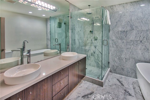 Primary bath w/double sink, tub & shower, mable walls & floors