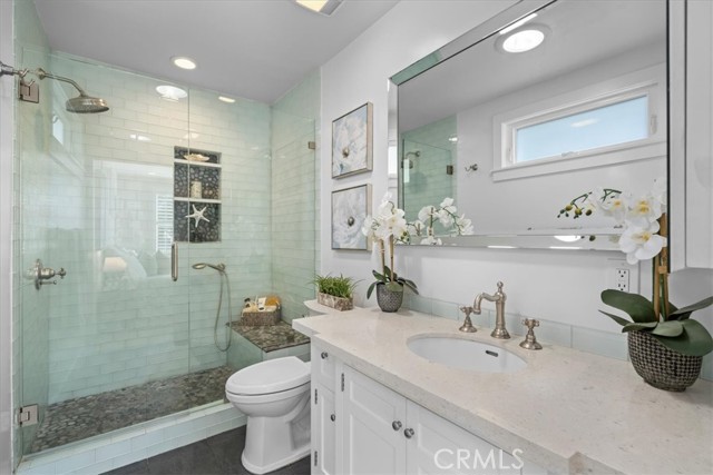 Completely remodeled bathroom has glass shower tile and large vanity/sink.