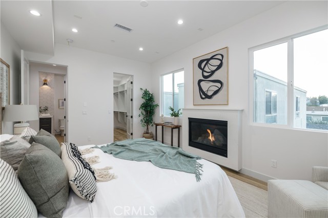 Master Bedroom with Expansive Walk-in Closet and Stylish Fireplace