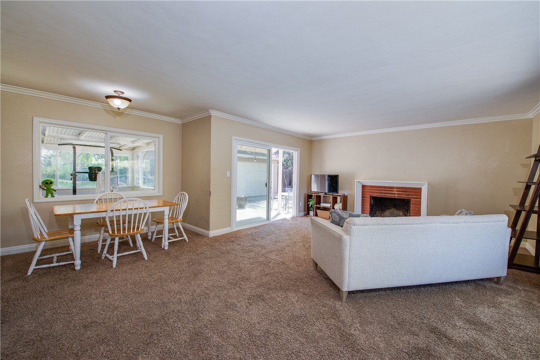 The living room is surrounded by crown molding and large baseboards with a fireplace in the center of the room.