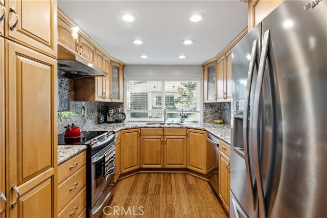 Updated kitchen with granite counters, warm wood cabinets, stainless appliances.