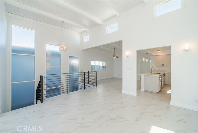 Clerestory windows above the dining room and kitchen with the stairway to the front door past the natural lighted windows.