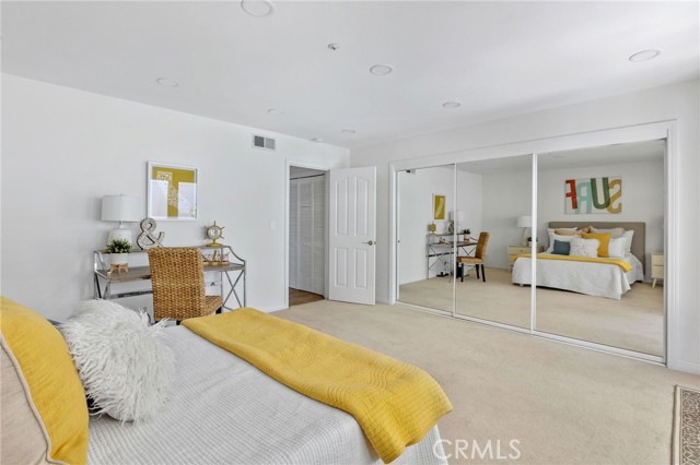 Canned lighting and a full length closet highlight this spacious bedroom.