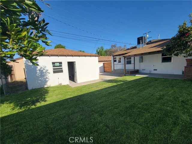 Spacious Backyard with Fruit Trees and Outdoor Covered Patio with Brick Fireplace