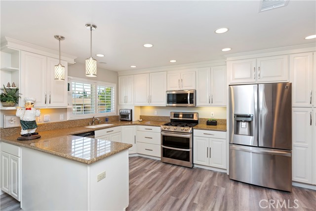 Kitchen - Beautiful hanging sconces shine down on the granite countertop.