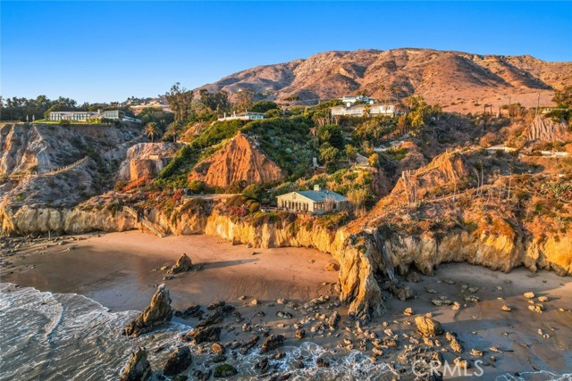 Indulge in idyllic living in this once-in-a-lifetime opportunity to own the former Disney Seaside Compound with access to a private secluded cove. Ideally set on 2.8 landscaped acres of prime oceanfront land in Malibu, it includes the main house with 6 bedrooms plus a 2-bedroom beach cottage. Impeccable craftsmanship is on display, from the elegant decorative molding and built-ins found throughout to the custom bar in the wood-paneled parlor. Viking stainless steel appliances, a generously sized island with a butcher block top, and a large pantry highlight a kitchen thats worthy of a professional chef. Breathtaking views greet you from nearly every room, including the primary suite complete with sitting room, fireplace, his & her bathrooms, a garden-style tub, and an expansive walk-in closets. Multiple decks offer sweeping ocean views and brilliant California sunsets. You and your guests will enjoy a pool and spa, plus a dramatic flagstone patio with an outdoor fireplace as well as multiple seating options for taking in the coastal vistas. Escape down the private driveway to find the fully equipped, sun-drenched guest cottage where vaulted ceilings with exposed beams await lucky visitors. Among the many other benefits this outstanding residence has to offer is the detached gym for working up a sweat and private stairs for direct beach access. Buyer to verify all information.