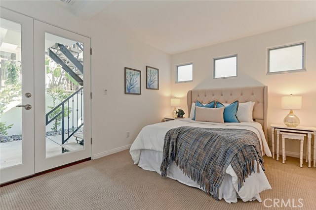 first level bedroom with set of patio doors and ensuite full bathroom