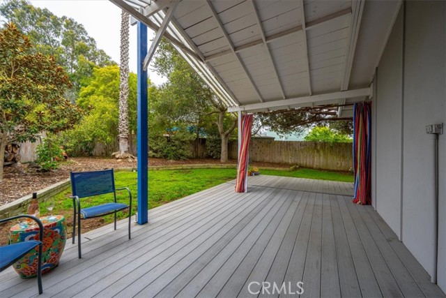Private covered deck located just off the primary bedroom with large backyard