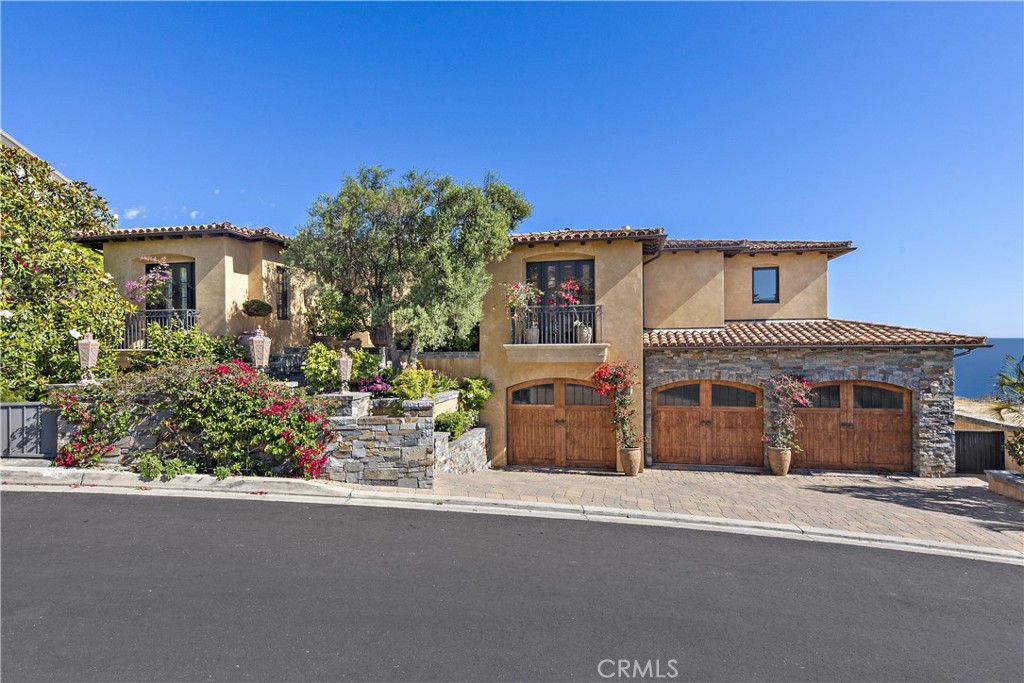 Step into coastal luxury at 20 Le Conte, a stunning Mediterranean-style masterpiece that welcomes you with panoramic ocean views from the moment you enter. Located in the gated community of Laguna Sur, this 5,062 sqft. home is a harmonious blend of exquisite architecture, open-concept design, and meticulous attention to detail, offering an unparalleled living experience.The main floor boasts an expansive layout where breathtaking ocean vistas flow seamlessly through the living room, and kitchen. The kitchen features a grand island, custom cabinetry, a massive walk-in pantry, and high ceilings adorned with striking exposed beams. Whether cooking, dining, or simply enjoying the view, this space is designed to impress. Step out onto the spacious balcony from the living room, where you can relax with the soothing ocean breeze, or sip your morning coffee while watching the waves. For the ultimate outdoor entertaining, the lower level features a fully equipped kitchen and dining area, perfect for hosting friends and family in style.This home’s interior delights continue with a state-of-the-art home theater, ensuring memorable movie nights and unparalleled indoor entertainment. With four luxurious bedrooms, four full bathrooms, and two half baths, everyone has their private retreat. The elevator adds convenience, seamlessly connecting all levels of the home, while the three-car garage and ample driveway parking ensure space for every guest. Every detail of this home is designed with comfort and elegance in mind, offering the perfect balance of upscale living and coastal relaxation. From its commanding ocean views to its impeccable finishes, 20 Le Conte is a dream come true. Don’t miss your opportunity to experience this extraordinary home.