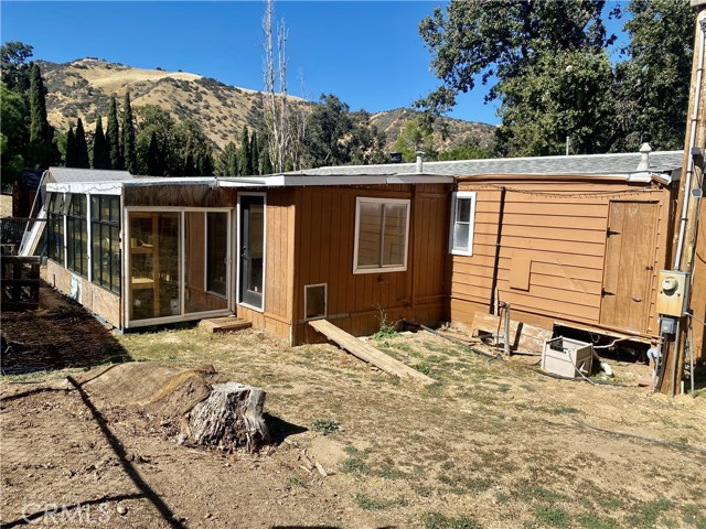 Back of home with greenhouse.