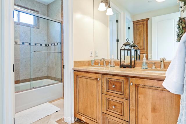 Lovely hall bath with double sinks and a shower/tub with decorative tile backsplash. Lovely hall bath with double sinks and a shower/tub with decorative tile backsplash.