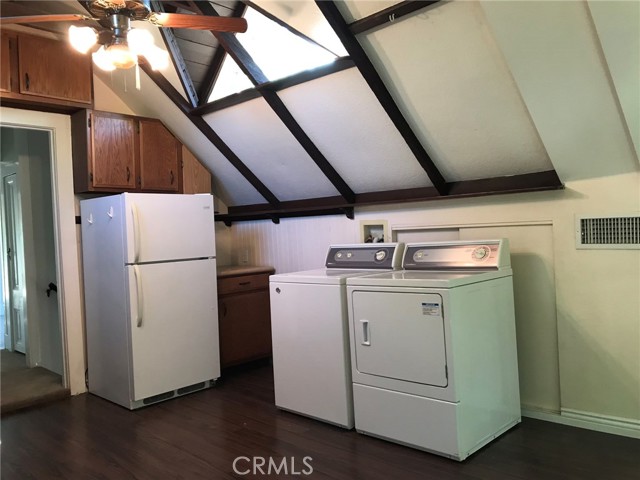 Opposite side of kitchen with refrigerator and full size laundry.