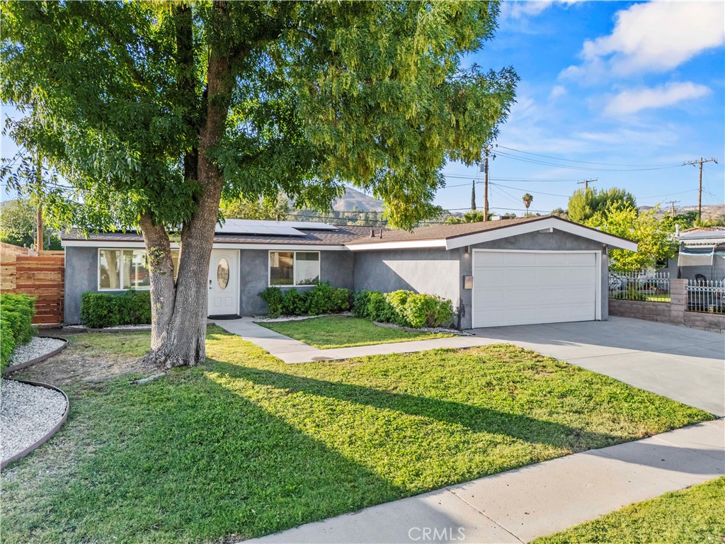 Stunning contemporary 3+2 single story in the heart of Santa Clarita.  You will appreciate this updated airy and bright remodeled home.  Upon entry the vaulted ceilings with recessed lights shine on the modern kitchen with stainless steel appliances, quartz counters and island dining.  Direct access through the slider to the oversized back yard and colored concrete patio for easy entertaining.  The floors are finished with commercial grade wood grain laminate making them both beautiful and practical. Both the Main bath and the bath in the primary suite have been completely redone with new fixtures, vanities, flooring, and subway tile.   The recent updates in this home are not just the ones you can see; but include additional wall and ceiling insulation for climate comfort, a radiant barrier energy efficient roof replacement, updated AC/Heat system, updated and expanded electrical panel, OWNED solar, copper plumbing, dual pane windows and sliding glass doors.  The exterior was just plastered, and the previous owner replaced the main sewer line.  Nothing to do but move in!   Walk to parks, highly rated schools, shops, and entertainment.   Entrance to the extensive Santa Clarita city bike trail less than a mile from the home.  The yard is oversized with mountain views and has enough space for your own oasis, pool or even an ADU.  Make your appointment soon – this one is going fast!