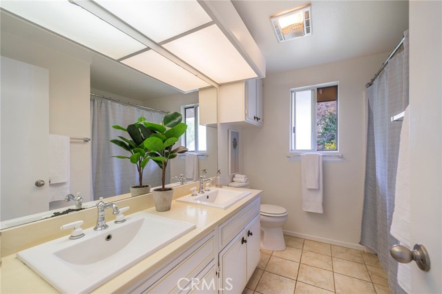 Full bathroom with double vanity in upstairs hallway