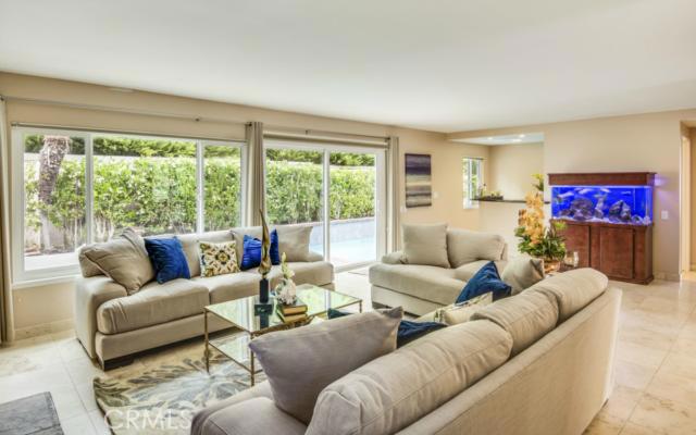 Beautiful travertine flooring throughout the mid level of the home. This room could be the family room with both a fireplace and a wet bar.