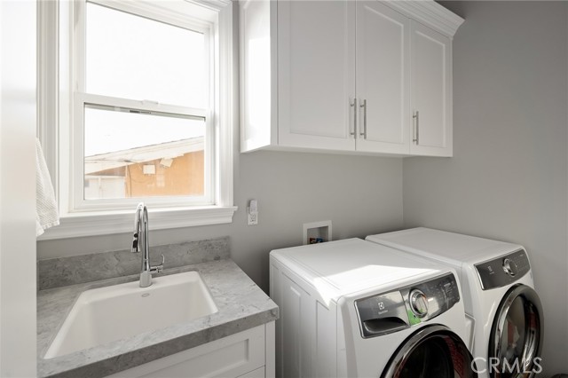 laundry room with cabinets and sink