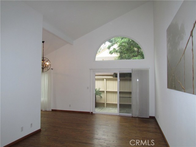 Living room with view from central hallway towards dining area. Custom kitchen is adjacent to dining area.