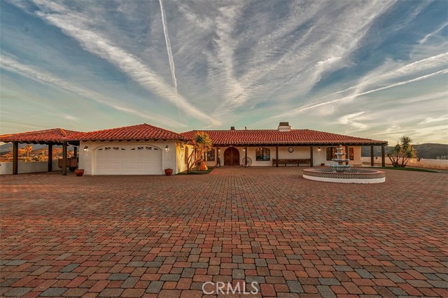 11755 Spade Spring Canyon Road Agua Dulce, California Look no further! This custom Spanish Revival home is for you! Built with the utmost quality construction in mind the solid custom entry door leads you to an Entertainers Dream! Spanish tile takes you room to room, with walls built two times the normal width, heavily insulated and textured to set the tone; Wide hallways; Three picturesque fireplaces throughout; Distressed wood beams in family room & custom tile hearth. Kitchen has solid oak cabinets, bay window, spacious island, Jen-air electric stove top & double oven. Matching built-in desk off kitchen. Master bedroom has cedar lined walk-in closet & french doors. Master bath has dual vanity sinks, skylights, soaking tub & separate shower. Individual laundry room w/tons of cabinets & stunning stain glass window. Low-e dual pane Pella windows throughout; Ceiling fans in every room. Living room has french doors that lead you to an incredible wrap around covered patio. Interior sprinkler system; Full copper plumbing; Solid core interior doors; 2 air conditioners; Exterior of home recently painted; Custom tile roof. Property is gated and fully fenced with Outstanding VIEWS and natural forest behind. Two-car attached garage with epoxy floors & additional carport PLUS a separate 4 car garage with roll-up doors & deep cabinetry, covered horse area off garage (approx. 10 x 10), tack room, office/workshop room & a Quonset hut with lights, fans and 100 amp panel (approx. 60 x 34). This home has it all! Buy today, entertain tonight!