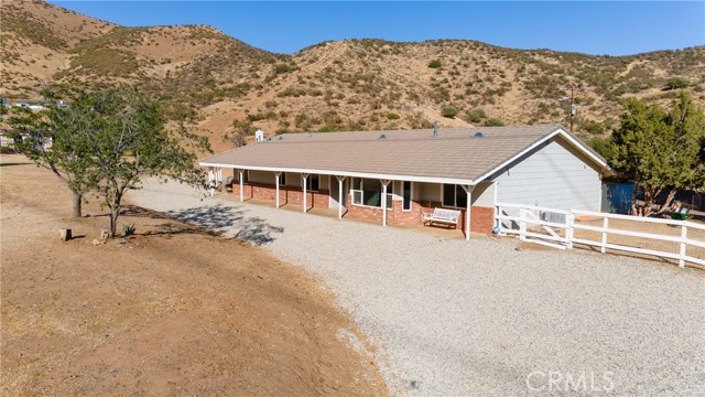 36240 Anthony Road Agua Dulce, California Beautiful Rancho La Milagrosa is a 5 bedroom, 4 bath, 3,738 sq. Ft. Single story ranch on a picturesque 7.74 acres. The home is a sprawling single story that almost lives likes 2 separate houses. The interior design and details will captivate you with an open floor plan, high ceilings, a spacious kitchen w/granite counters, stainless steel appliances, center island with cooktop, breakfast bar, and country kitchen dining room with views into the gorgeous common family room with fireplace, Custom bar area, and a beamed ceiling. The right side of the home has a separate living room, 3 bedrooms, and 2 full baths, including a master suite with walk-in closet, a private sitting area/patio, and a gorgeous master bath w/ tile floors, double sinks, and a separate tub and shower. The left side of the home is separated by a second Private entry, and huge laundry room That has hookups for 2 washers and 2 dryers. This wing of the property has a living room, a game room, and 2 bedrooms including a second master bedroom with an updated tile shower enclosure, and sink area with granite counter. Outside is where the home really shows it’s possibilities with a backyard area that is fenced in with a side area with tree swing and room for storage etc. Got horses? Need to build a workshop? Then look no further than the large graded areas out in front of the house. There is room for a riding arena, barn, stables or whatever your plans may include, and the possibilities are endless. A 2 stall barn and pipe corrals are on the property, along with a 10,000 gallon Water Storage Tank, an enclosed well house, and for gas, there is a propane tank. Come enjoy the views that are literally all around you, and make Rancho La Milagrosa your new home.