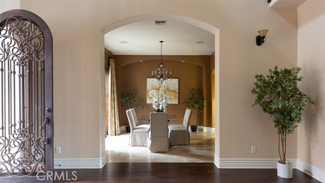 Formal Dining Area Open to views of courtyard and Sweeping Staircase.