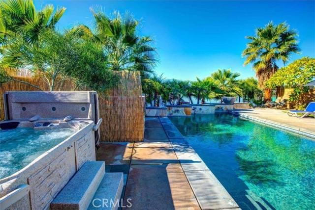 42861 Beato Drive Indio, California This is a rare lakefront desert home in a prime location. Former model home. Ideally, positioned with a secluded backyard, 180-degree panoramic views, of the magnificent lake, bridge, and Southern mountain views including Mt. San Jacinto and the Santa Rosa Mountains. The only southwest facing lot on the lake that allows privacy and views at the same time. Location, Location, Location! Just imagine entertaining guests or you, lounging by your own oversized private saltwater pool and hot tub enjoying the views, or drinks and dining on the deck and covered patio while enjoying a spectacular sunset view across the lake or the gorgeous mountains in the distance. This place is a stunning setting to say the least! The solar panels are all yours, they have been paid-for! Indoors, you'll love the open concept living room with hardwood flooring, a built-in entertainment center and a cozy natural gas fireplace. The chef's kitchen has stainless steel appliances, granite countertops, a sizable island, quality cabinets, and plenty of storage; a breakfast bar that is open to the Dining area and living room. The spacious master retreat with a walk-in closet, full bathroom with dual vanities, oval jetted tub and glass enclosed shower, and mountain views. Terra Lago is a guard gated community with low HOA dues and offers a man-made lake for electric boats and catch & release fishing. The clubhouse is a short stroll away. Terra Lago features a playground, community pool and spa, Clubhouse, fitness center and game room as well as a cable/internet service package. Furniture negotiable, outside escrow.