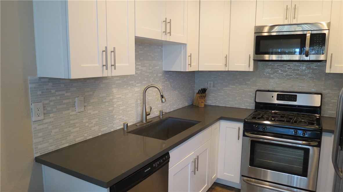 New white cabinets, Quartz Stone Counters, linear glass back splash, stainless dishwasher, stove/oven and microwave