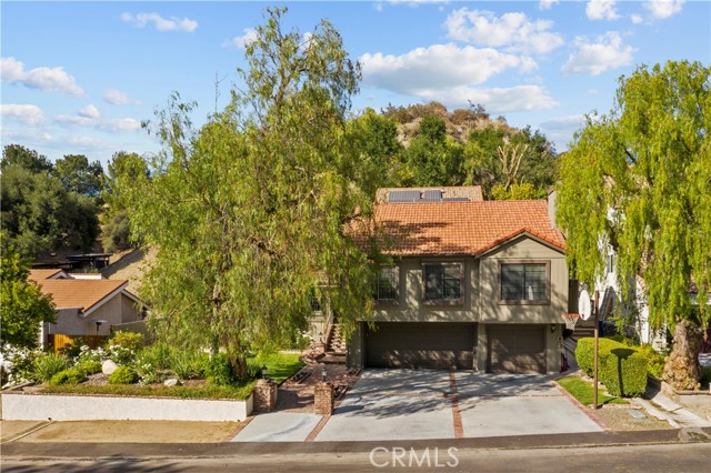 23815 La Salle Canyon Road Newhall, California Situated in the prestigious Rancho La Salle Gated community of 52 acres, only 25 large-lot homes sit on this cul de sac. For the first time on the market, this customized home has been enlarged to add more livable space. Custom brick hardscape and lighted pilasters welcome you to the home. This split-level home has an indoor atrium creating a “wow-factor” when you first enter. This adds plenty of light & brightness. Beautiful leaded glass front door & sidelight open to a large living room with soaring ceilings, brick fireplace and large picture windows. There are ceiling fans throughout the home. The Family room has wood flooring, vaulted ceilings with French sliders that take you out to the back patio and pool.
Kitchen is open to the raised dining room with wood flooring and an overview of the living room. The large Kitchenaid Refrigerator stays with the home. There are custom oak cabinets, tile counters with a serve through counter to the Family room.
Besides the numerous bedrooms and bathrooms, you have a gym and a large bonus room with a fantastic stone & brick fireplace with a raised hearth, large picture windows, window seat, wet bar, raised area for pool table–which is included—and a spectacular wood vaulted ceiling. The large private Master suite is on its own level with walk-in closet and huge master bath. You have an indoor laundry room with sink and counterspace plus the newer washer & dryer are included. There is a newer water heater, solar panels, entry to the 3-car garage is from the lower level, plus ample space for parking. You have dining and lounging in the back yard with a child-safe pool that has a waterfall/slide with custom brick & stonework. Beautiful Oak trees. Wonderful private area to entertain, relax and play. Commuters--enjoy the quick access to the 5 Freeway. Great schools, great shopping and entertainment very close by. No Mello Roos. Homes rarely come up for sale in this gated community.