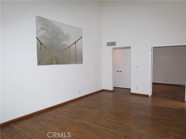 View from dining area towards central hallway and second bedroom. Washer dryer closet doors in hallway at right side of image.