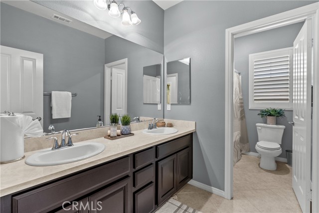 upstairs hall bathroom with dual sink and tub/shower