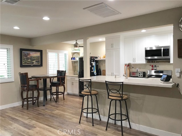 View of kitchen, dining area and dry bar from bottom of living room staircase